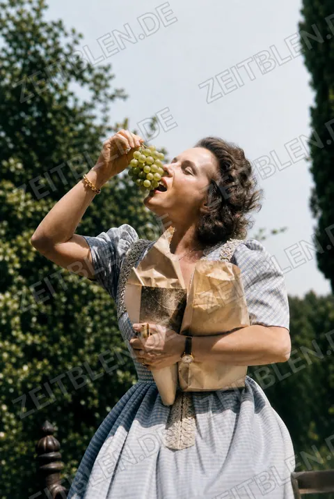 Magda Schneider mit Weintrauben im Freien