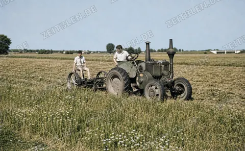 Traktor mit Feldgerät bei der Erntearbeit, 27. August 1949
