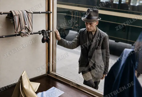 Mann vor einem Münchner Schaufenster mit Krawatten und Accessoires