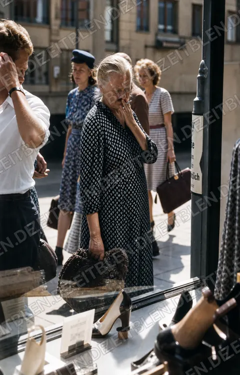 Frauen vor einem Münchner Schaufenster mit Textil- oder Haushaltswaren