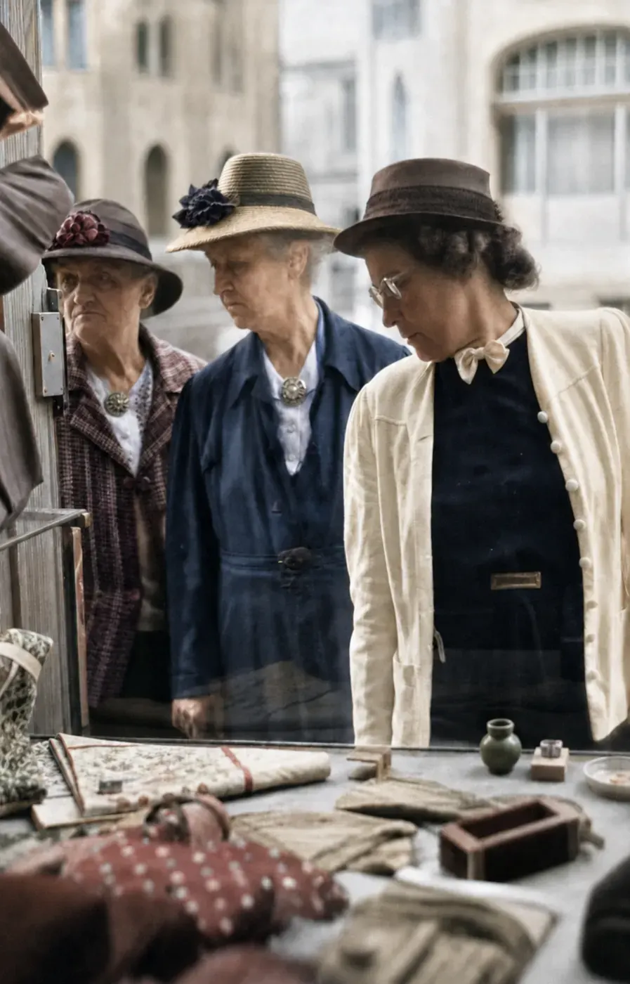 Drei Frauen mit Hüten vor einem Münchner Schaufenster