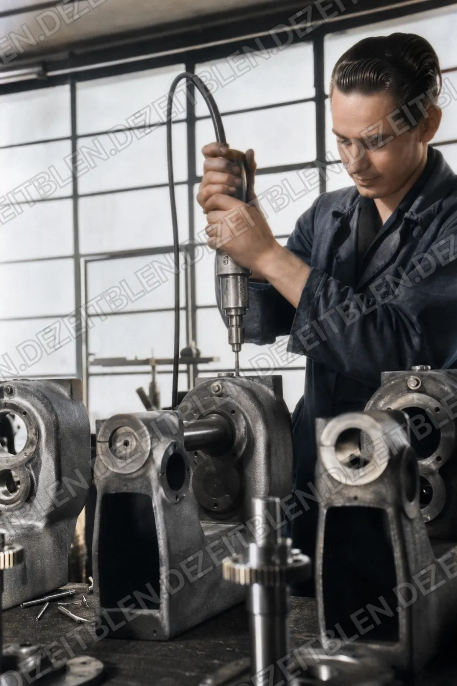 Arbeiter mit Handbohrmaschine an Werkzeugmaschine