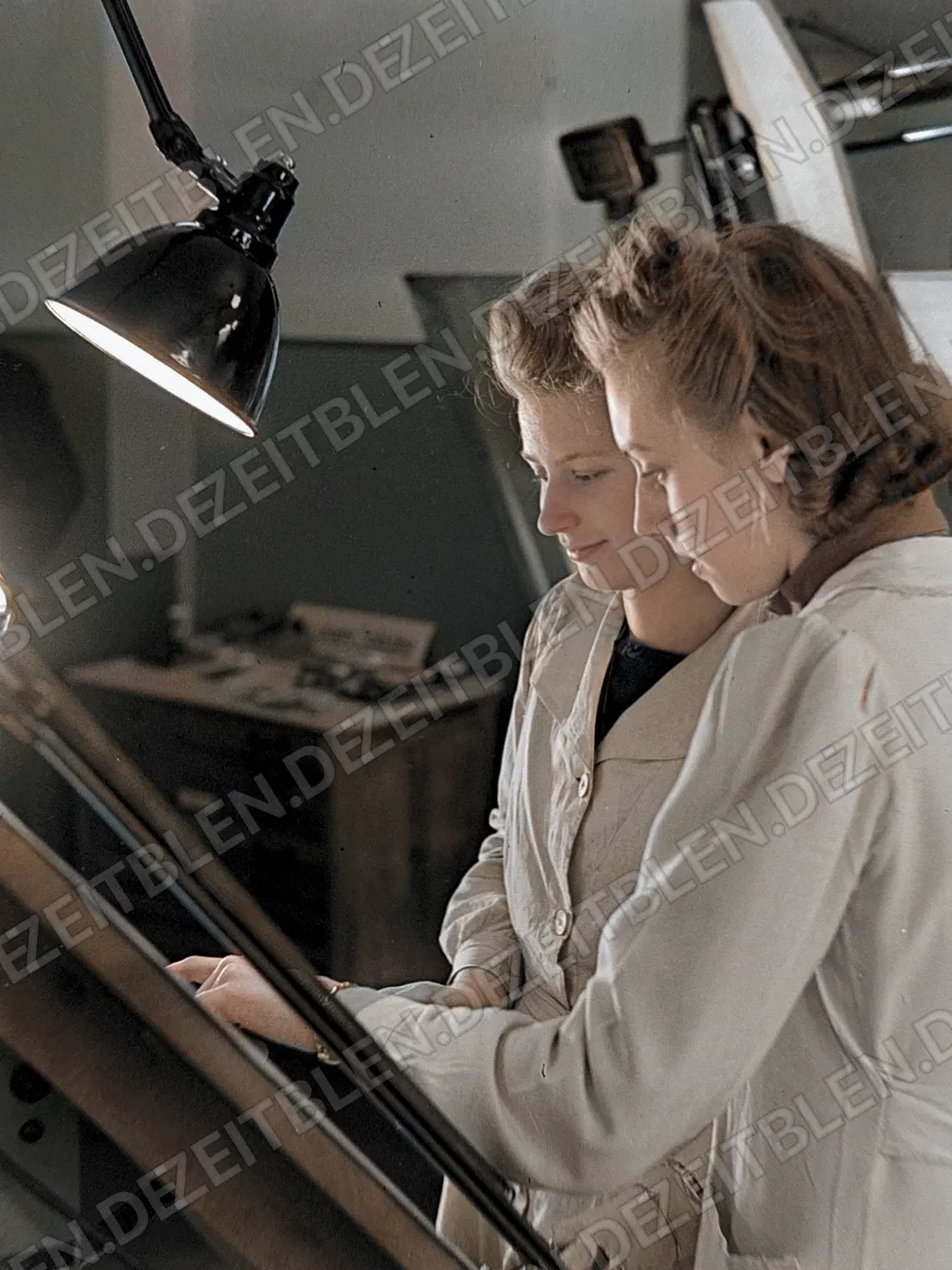 Zwei Frauen an technischen Plaenen