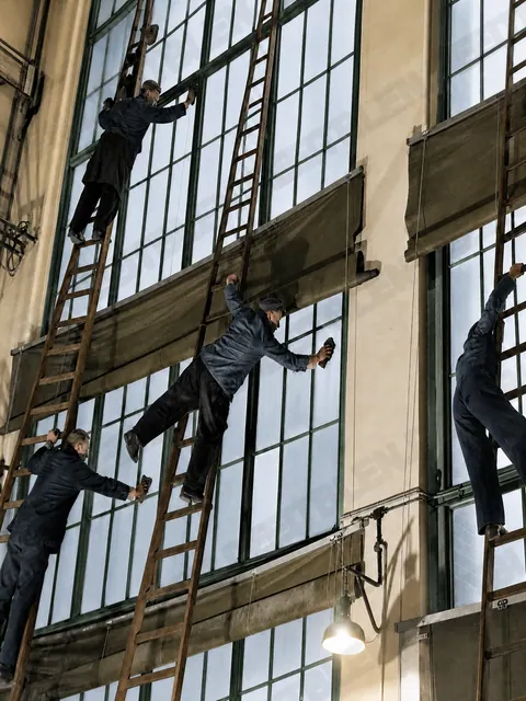 Fensterputzer auf Leitern in einer AEG-Halle