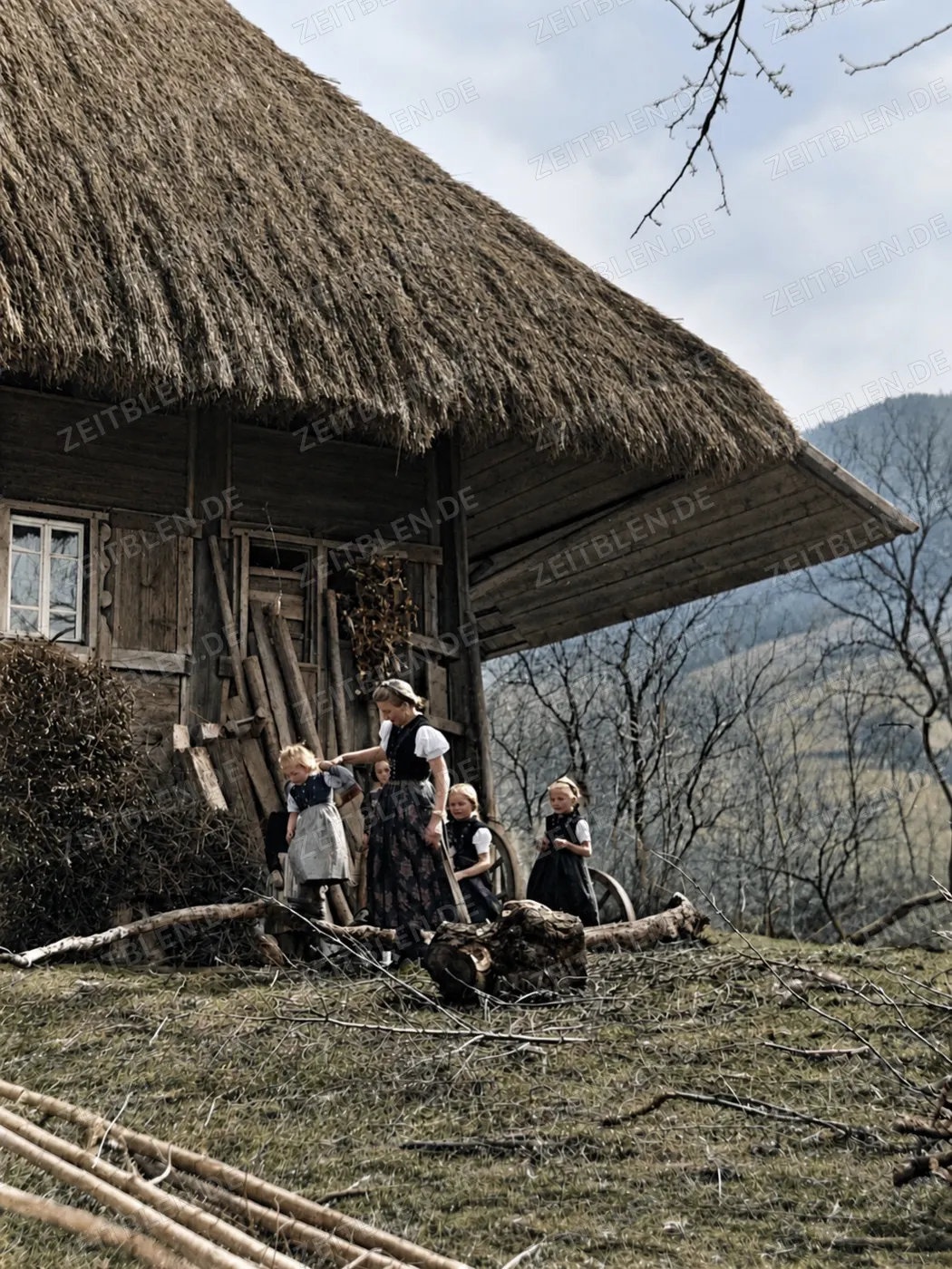 Kinder und Erwachsene an einem Bauernhof in den 1930er Jahren