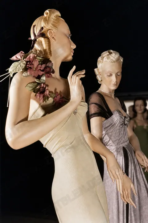 Modepuppen mit Blumenschmuck und drapierter Damenmode