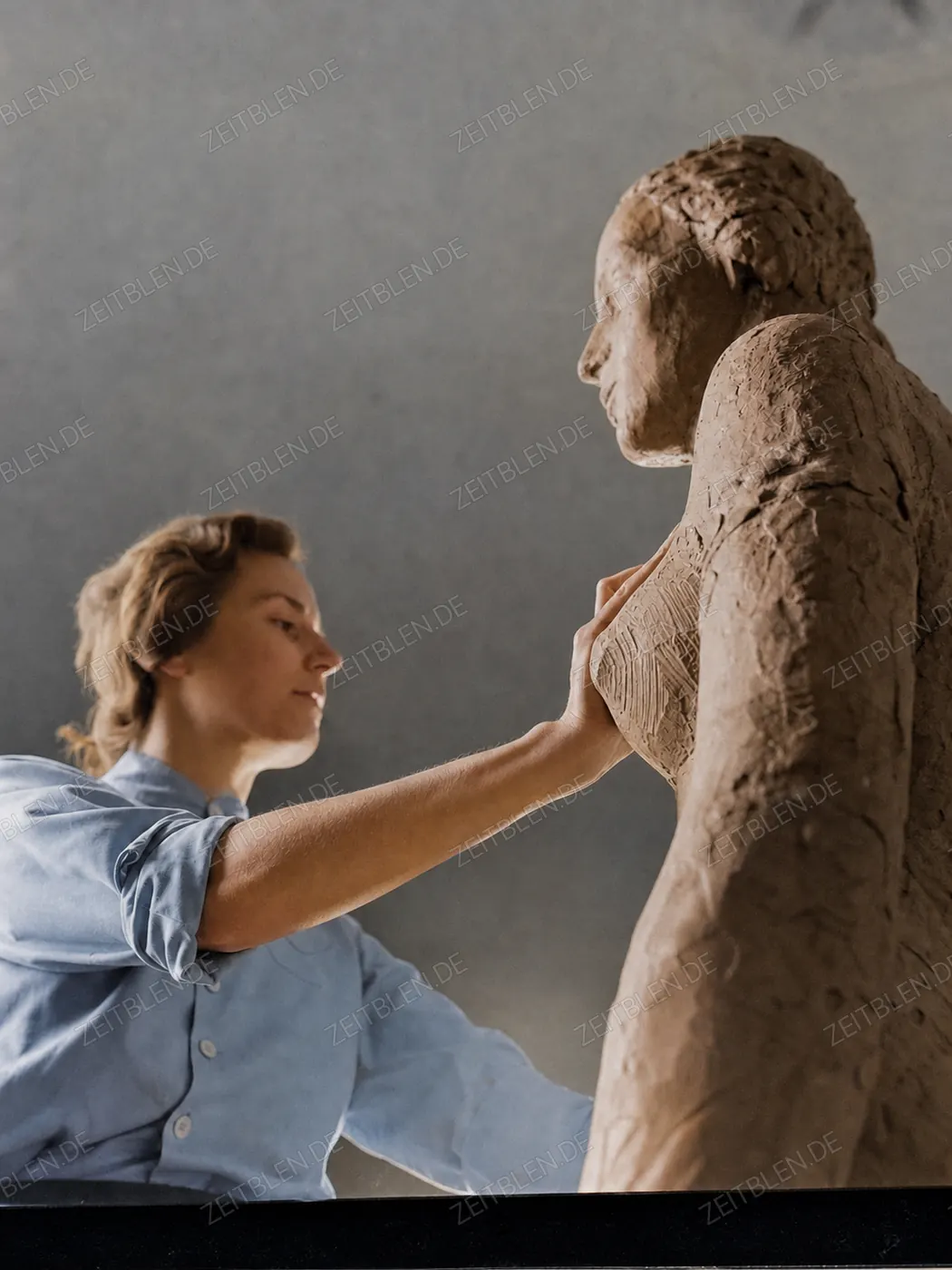 Bildhauerin beim Bearbeiten einer Figur im Atelier