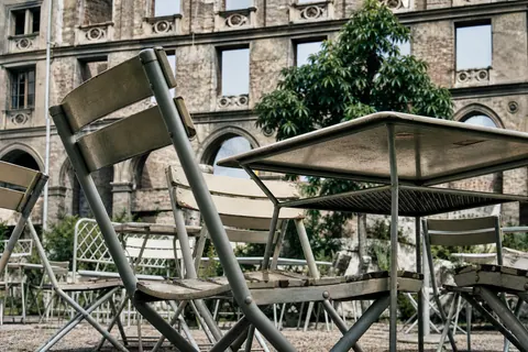 Lokal im Sommer vor einer Ruinenrückwand in München