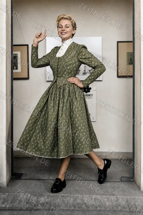 Lodenfrey-Modefoto mit gemustertem Kleid vor Schaufenster