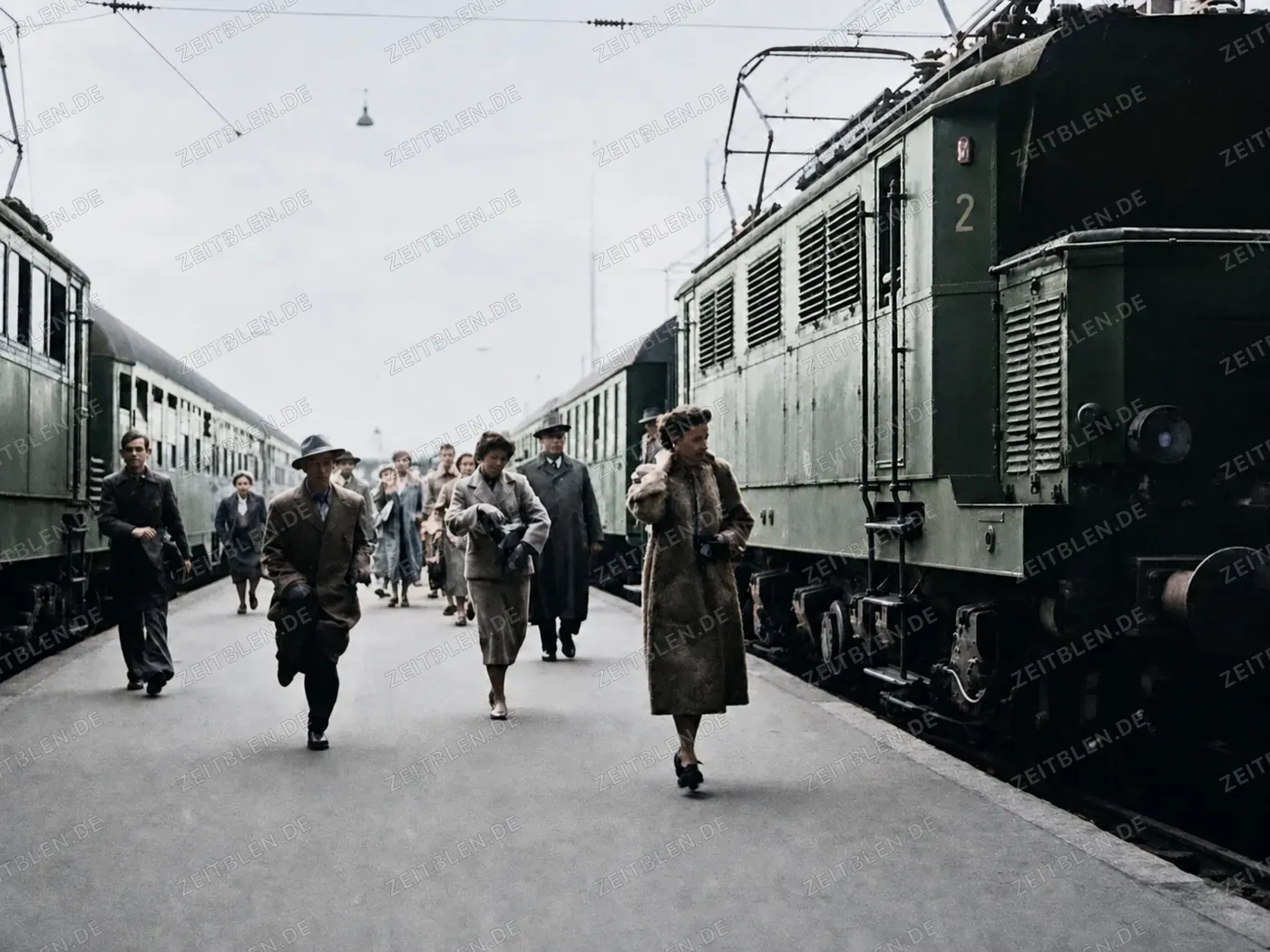 Reisende neben Lokomotive am Bahnsteig, München 1954