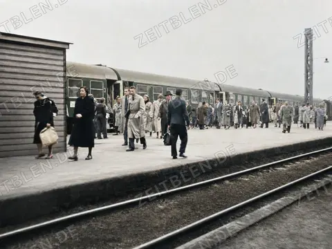 Reisende vor Personenwagen am Bahnsteig, München 1954