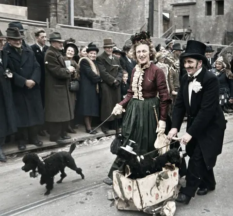 Kostümiertes Paar mit kleinen Hunden beim Faschingsumzug, 27. Februar 1949