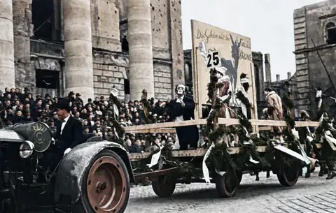 Festwagen 25 vor kriegsbeschädigter Fassade beim Münchner Faschingsumzug, 27. Februar 1949