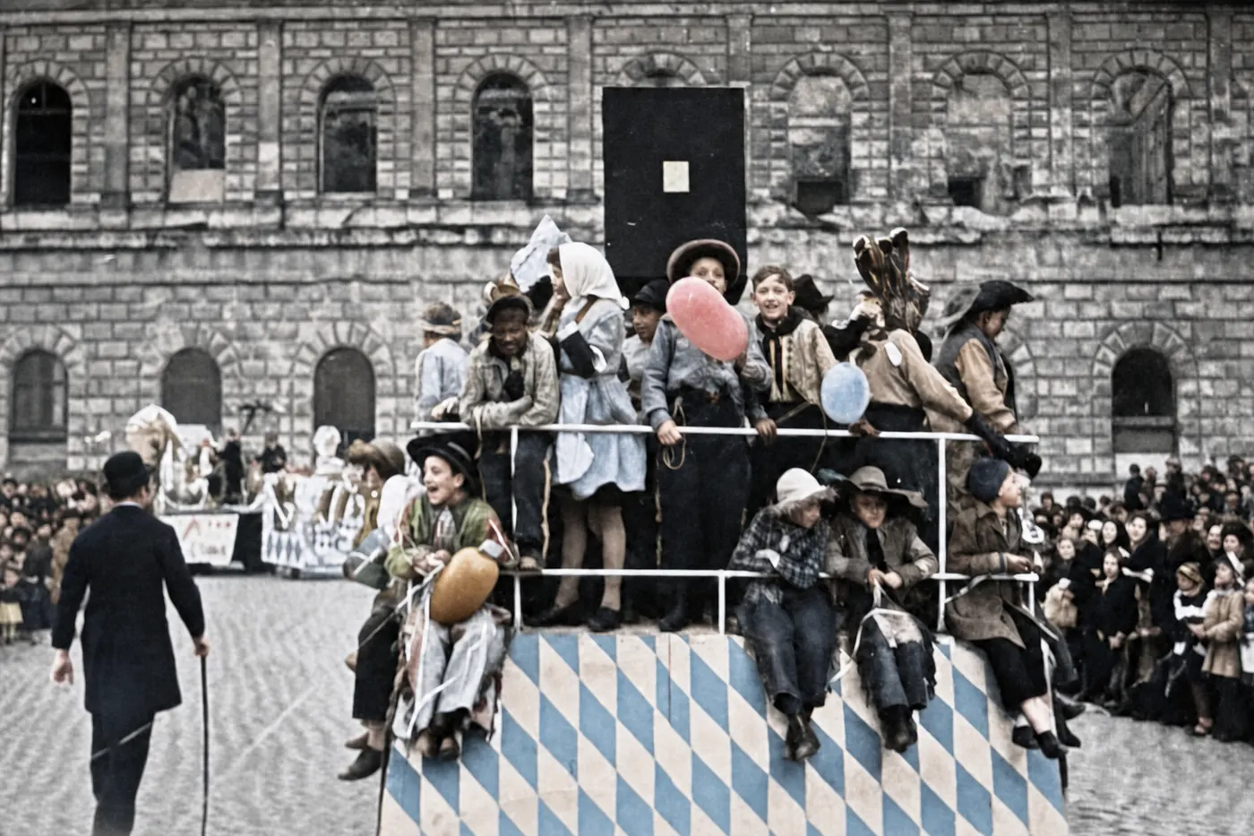 Rautenverzierter Kinder-Festwagen vor Zuschauertribüne beim Münchner Faschingsumzug, 27. F