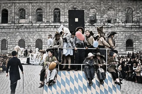 Rautenverzierter Kinder-Festwagen vor Zuschauertribüne beim Münchner Faschingsumzug, 27. Februar 1949