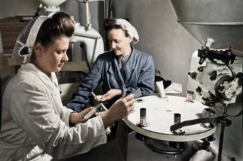 Arbeiterinnen beim Bestücken einer Verpackungsmaschine bei den Trineral-Werken, München, 10. März 1949