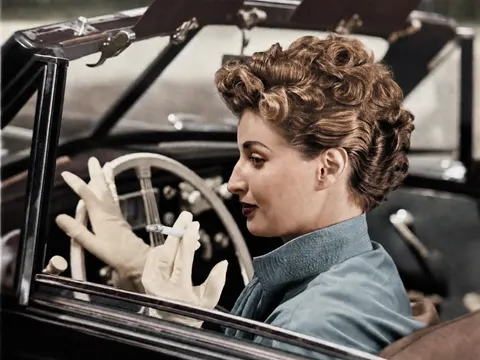 Selbstbewusste Frau mit Zigarette im offenen Wagen, August 1952