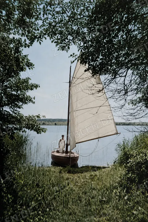 Segelboot am bewachsenen Ufer