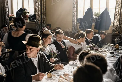 Hochzeitsgäste mit Krügen an der Festtafel, 1936