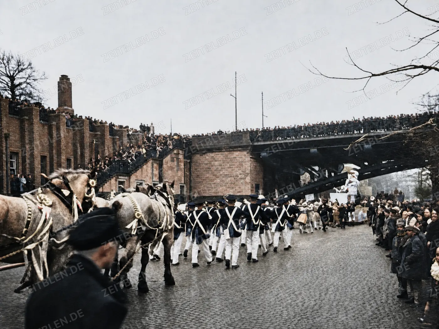 Karnevalszug unter einer dicht besetzten Eisenbahnbrücke in Düsseldorf, 1937
