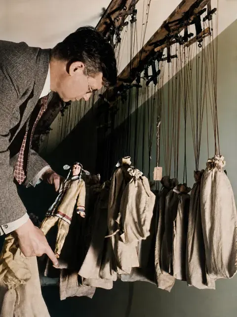 Puppenspieler hinter den Kulissen eines Marionettentheaters