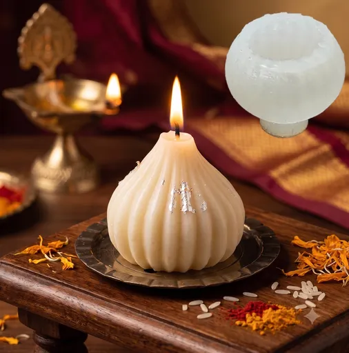 Lit white modak-shaped scented candle with silver foil on a brass plate for festive Indian decor.