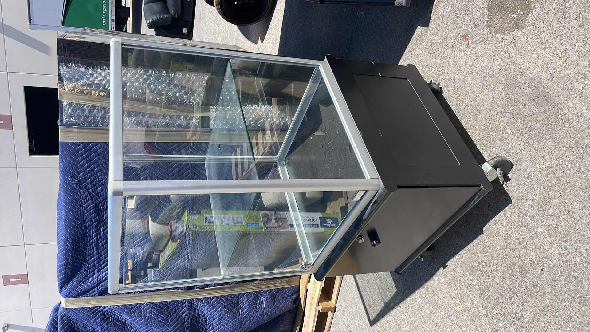 Photo 2 of GLASS DISPLAY CASE ON WHEELS 23” x 23” x 48” LOCKED AND NO KEYS