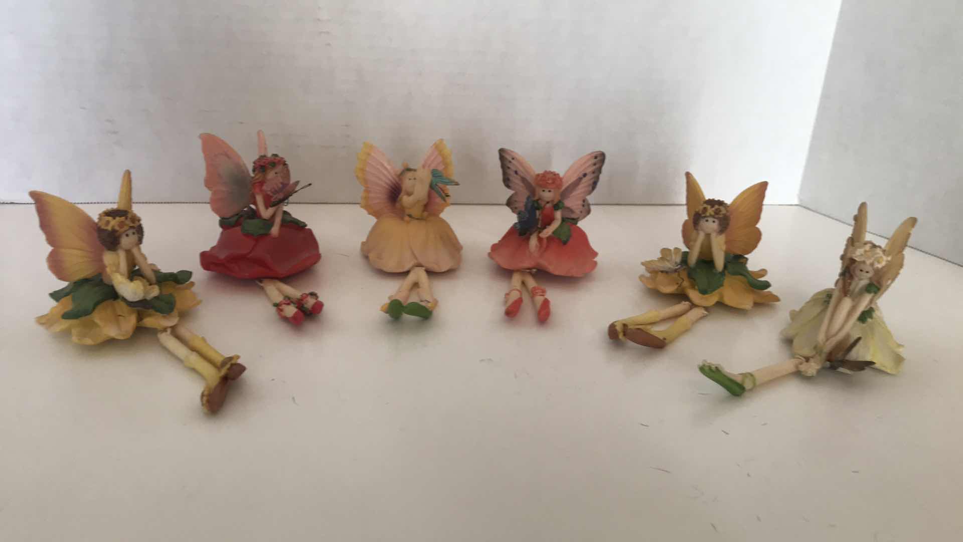 Photo 1 of COLLECTION OF SIX CERAMIC FAIRIES WITH DANGLING LEGS, APPROX 4” SITTING