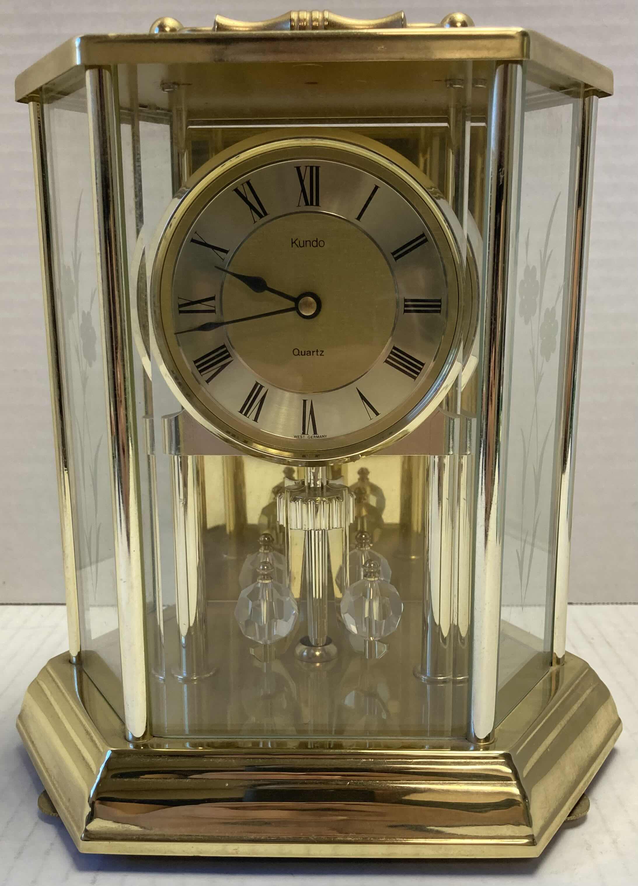 Photo 1 of KUNDO GOLD FINISH QUARTS BATTERY OPERATED CLOCK W ROTATING PENDULUM 8.5” X 5.75” H8.5”