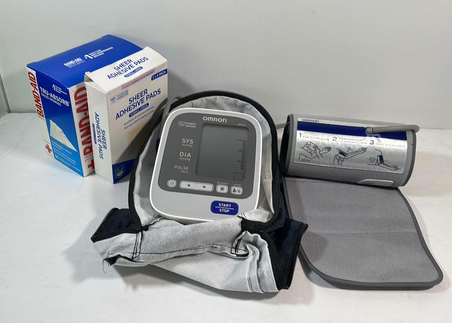 Photo 1 of OMRON BLOOD PRESSURE MONITOR MODEL BP762 & TWO BOXES OF BAND-AID