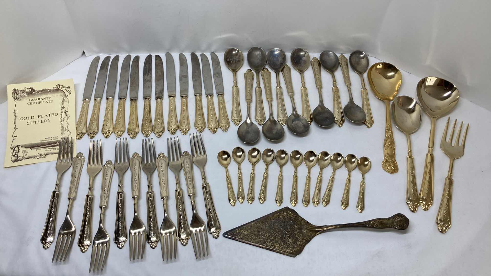 Photo 1 of LBL ITALY GOLD FINISH EP ZINC PLATED FLATWARE (36) W VARIOUS GOLD FINISH SERVING WARE (2) & FLATWARE RACK