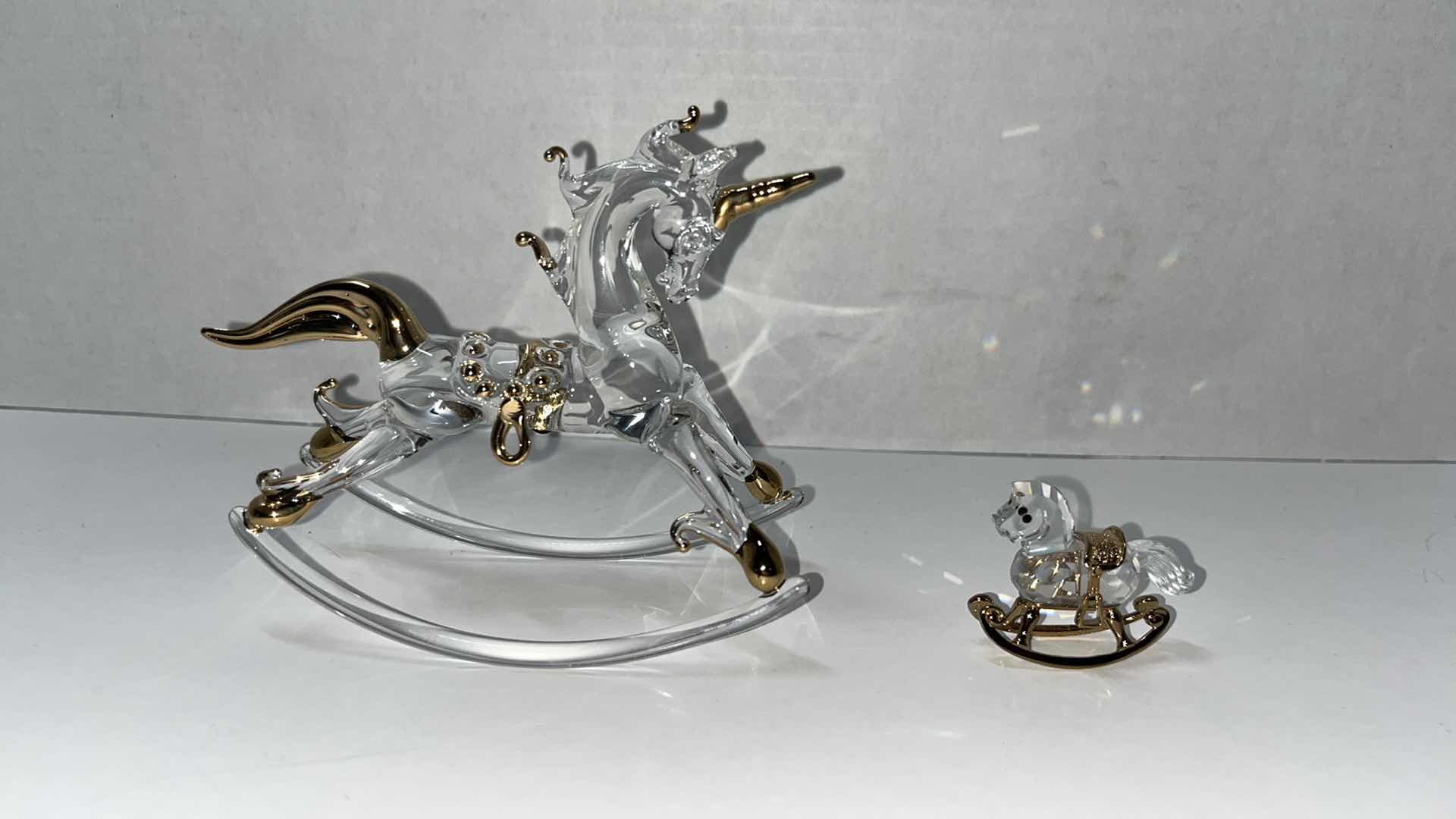 Photo 1 of HAND BLOWN CLEAR GLASS ROCKING UNICORN W GOLD ACCENTS 4.75” X 2” H4”W CRYSTAL ROCKING HORSE W GOLD ACCENTS (2)