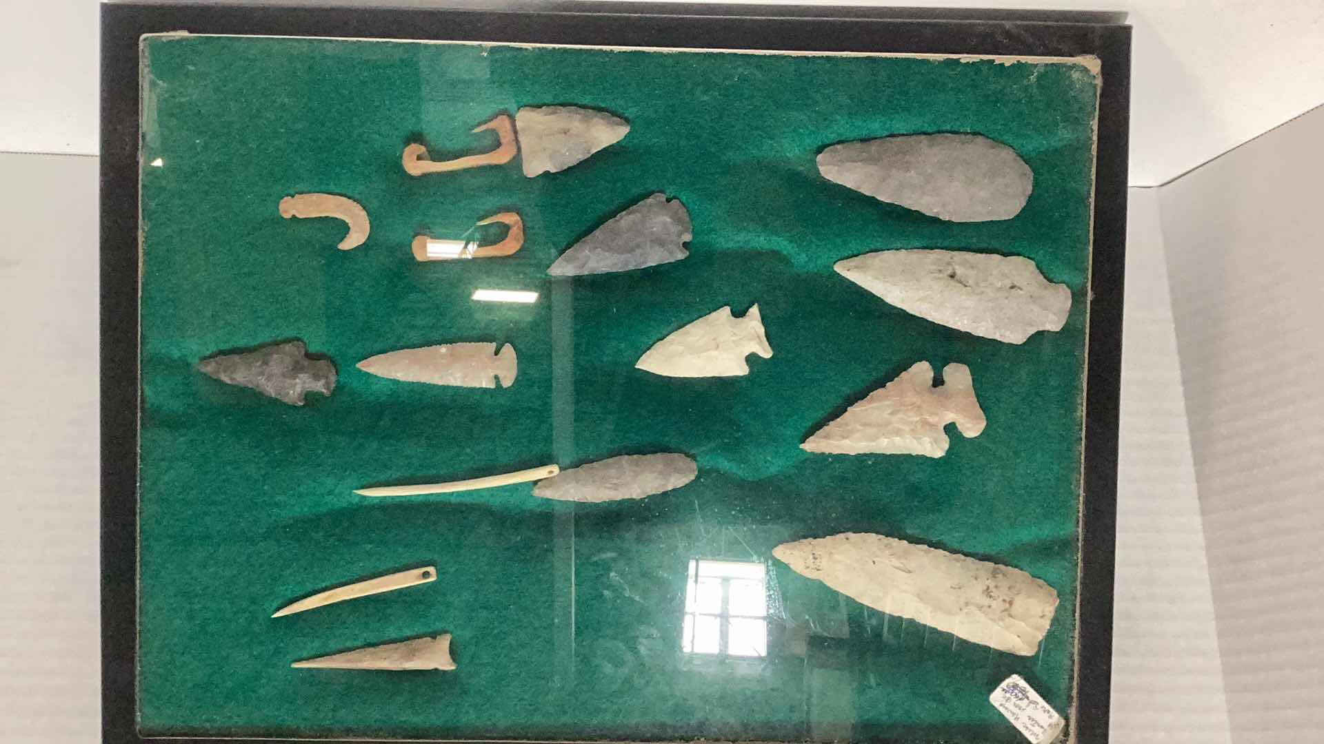 Photo 1 of RARE ANTIQUE NAVAHO MISCELLANEOUS HUNTING ITEMS. CIRCA 1600 B.C. ARROWHEADS, NEEDLES, AND FISH HOOKS CASE 12” X 17”