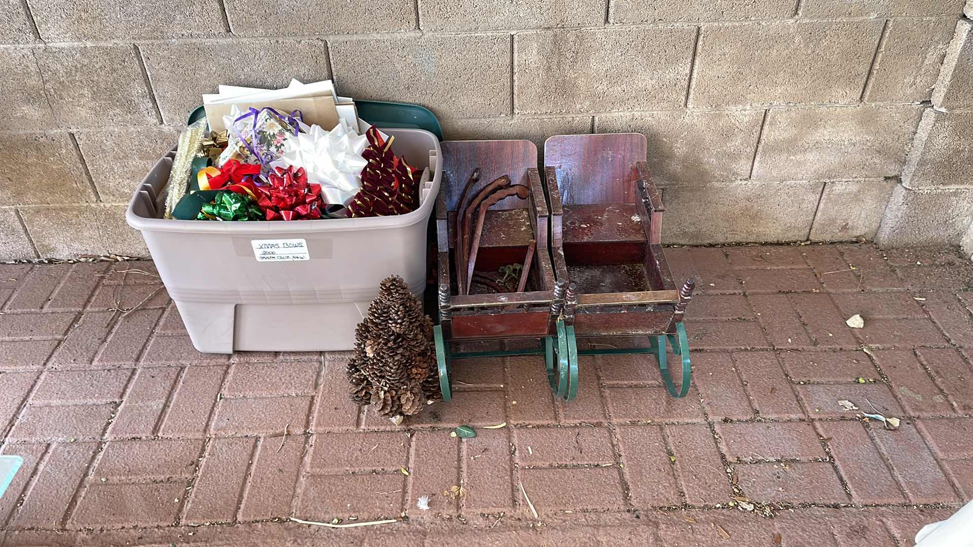 Photo 1 of TWO DECORATIVE WOOD AND METAL SLEDS (L-26”), ARTISTIC PINECONE TREE, & LARGE PLASTIC BIN FULL OF CHRISTMAS ACCOUTERMENT.