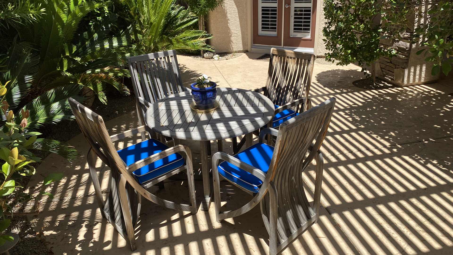 Photo 2 of TEAK WAREHOUSE DINING SET WITH 4 CHAIRS MARINE BLUE WATER REPELLANT AND SUN PROTECTION FABRIC AND POTTED PLANT - TABLE 43” H29” 