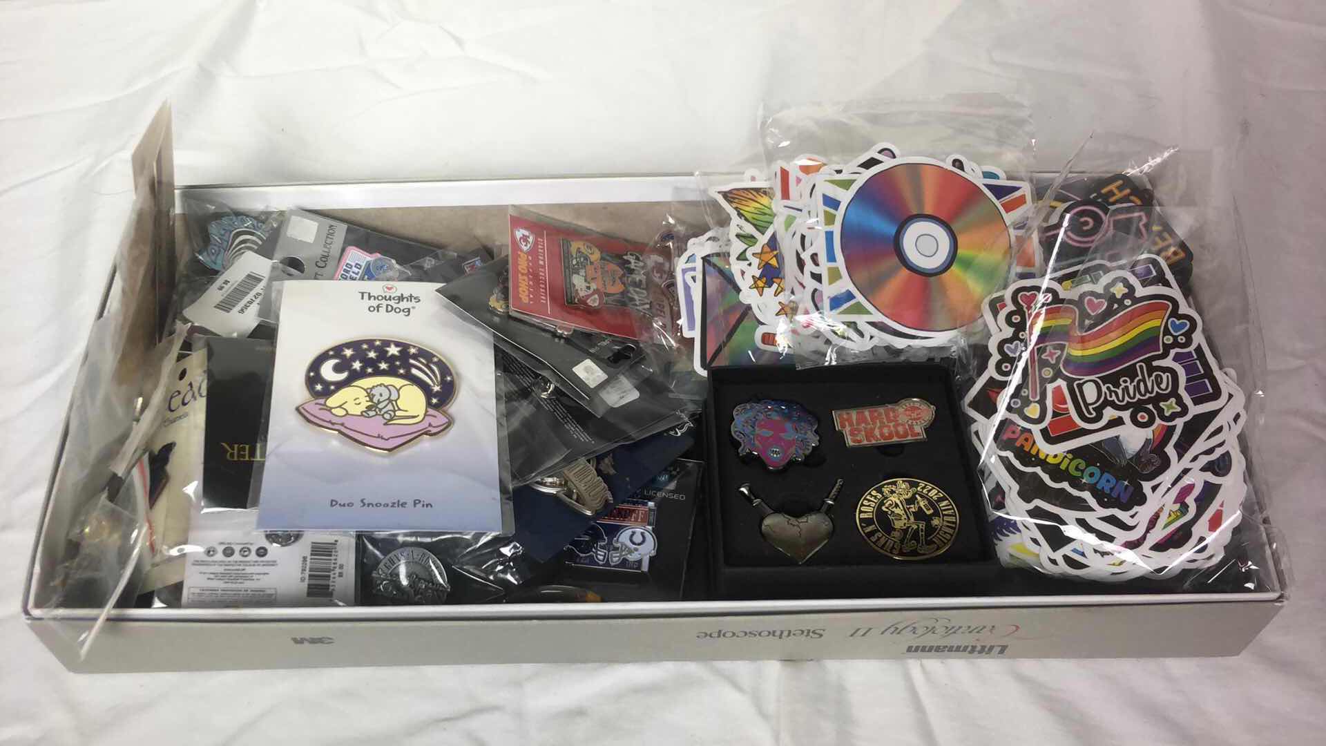 Photo 1 of BOX OF APPROX 200 STICKER DECALS AND 50 METAL PINS (GUN N ROSES, NFL FOOTBALL, MISC AND MORE