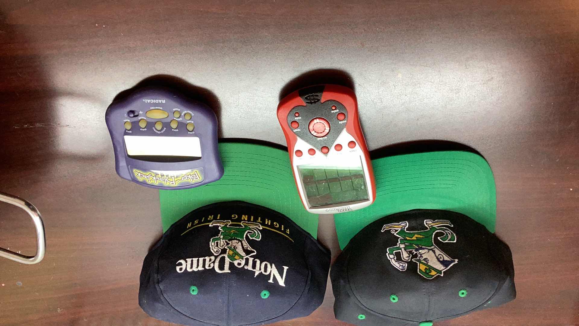 Photo 1 of 2 NOTRE DAMN FOOTBALL CAPS AND HANDHELD GAMES