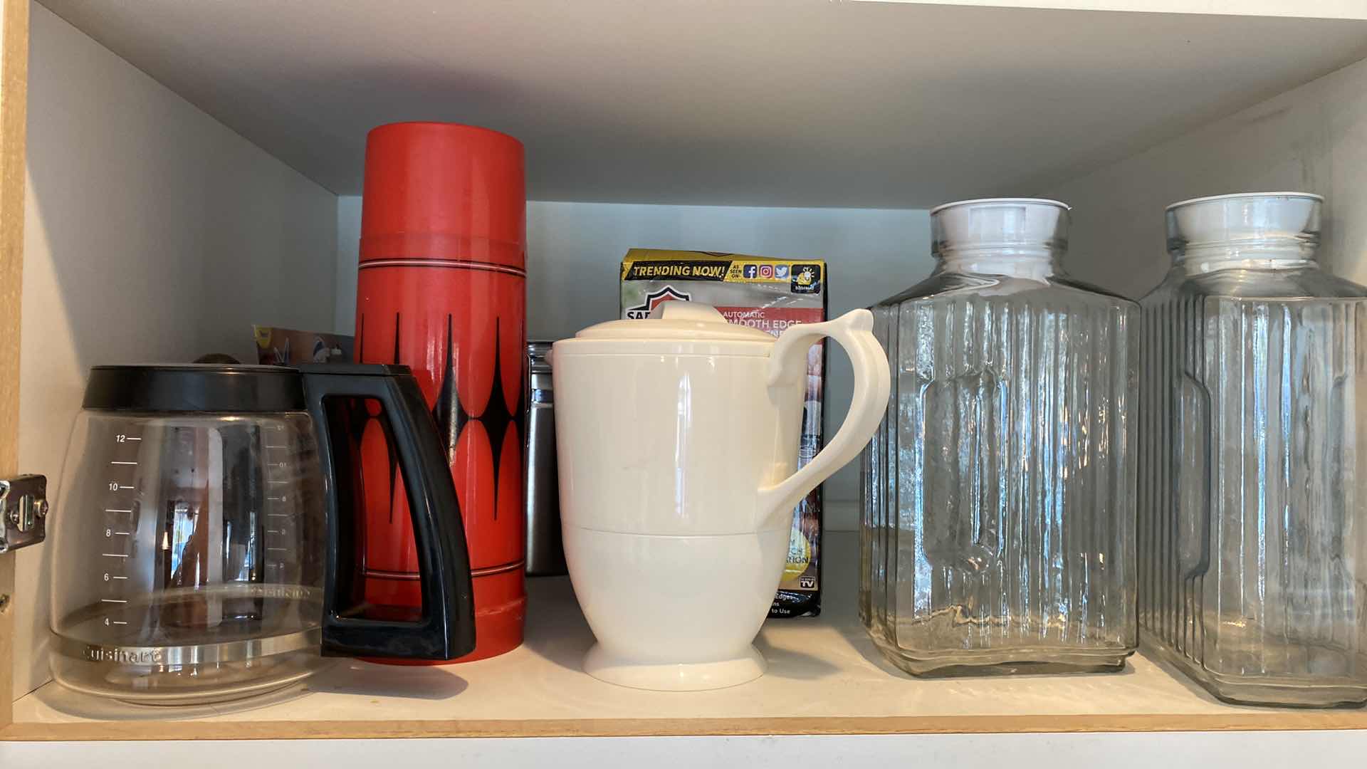 Photo 1 of CONTENTS OF KITCHEN CABINET ABOVE OVEN - GLASS JUICE PITCHERS AND MORE