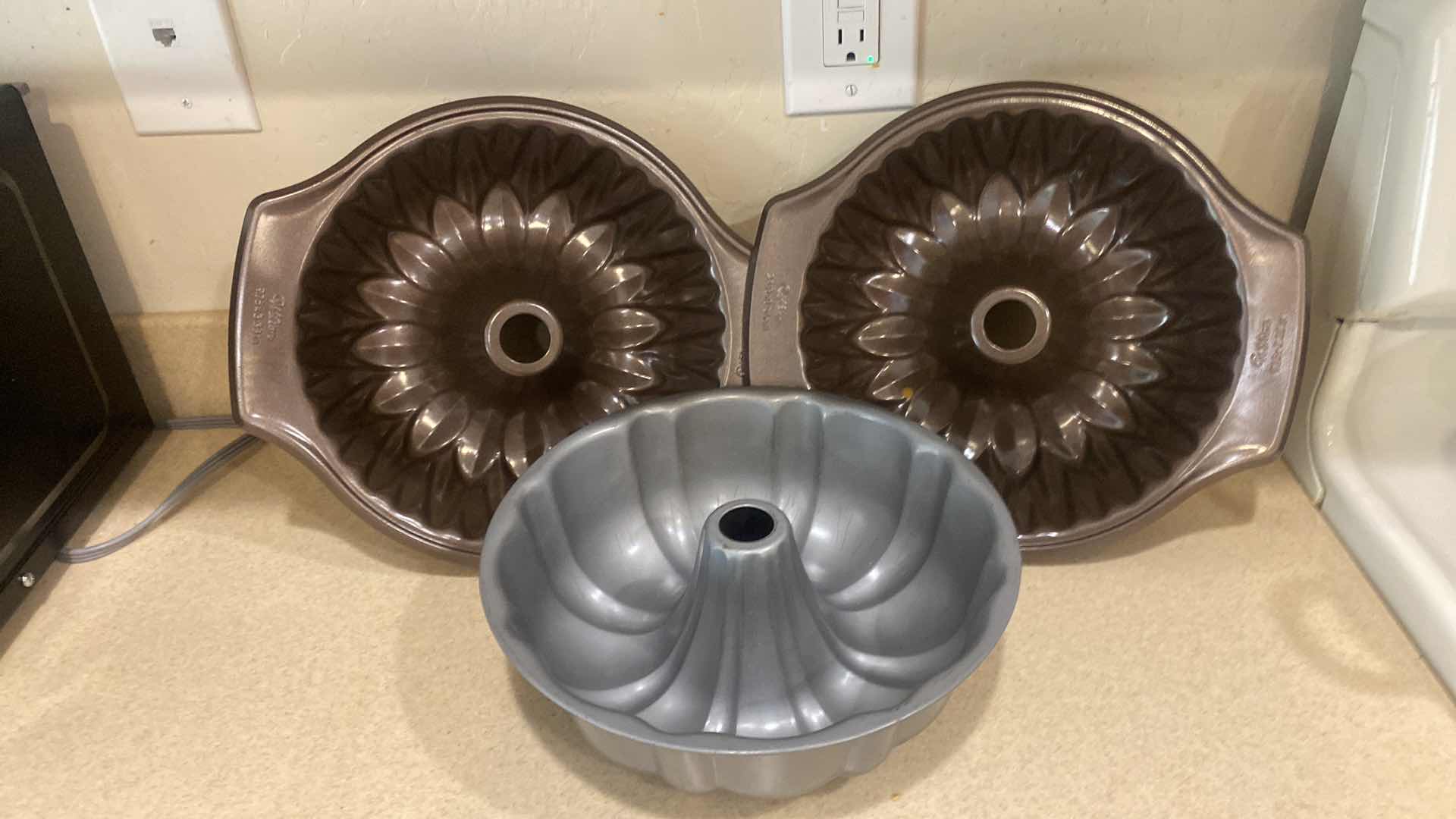 Photo 1 of CONTENTS OF KITCHEN CABINET- 3 BUNDT PANS