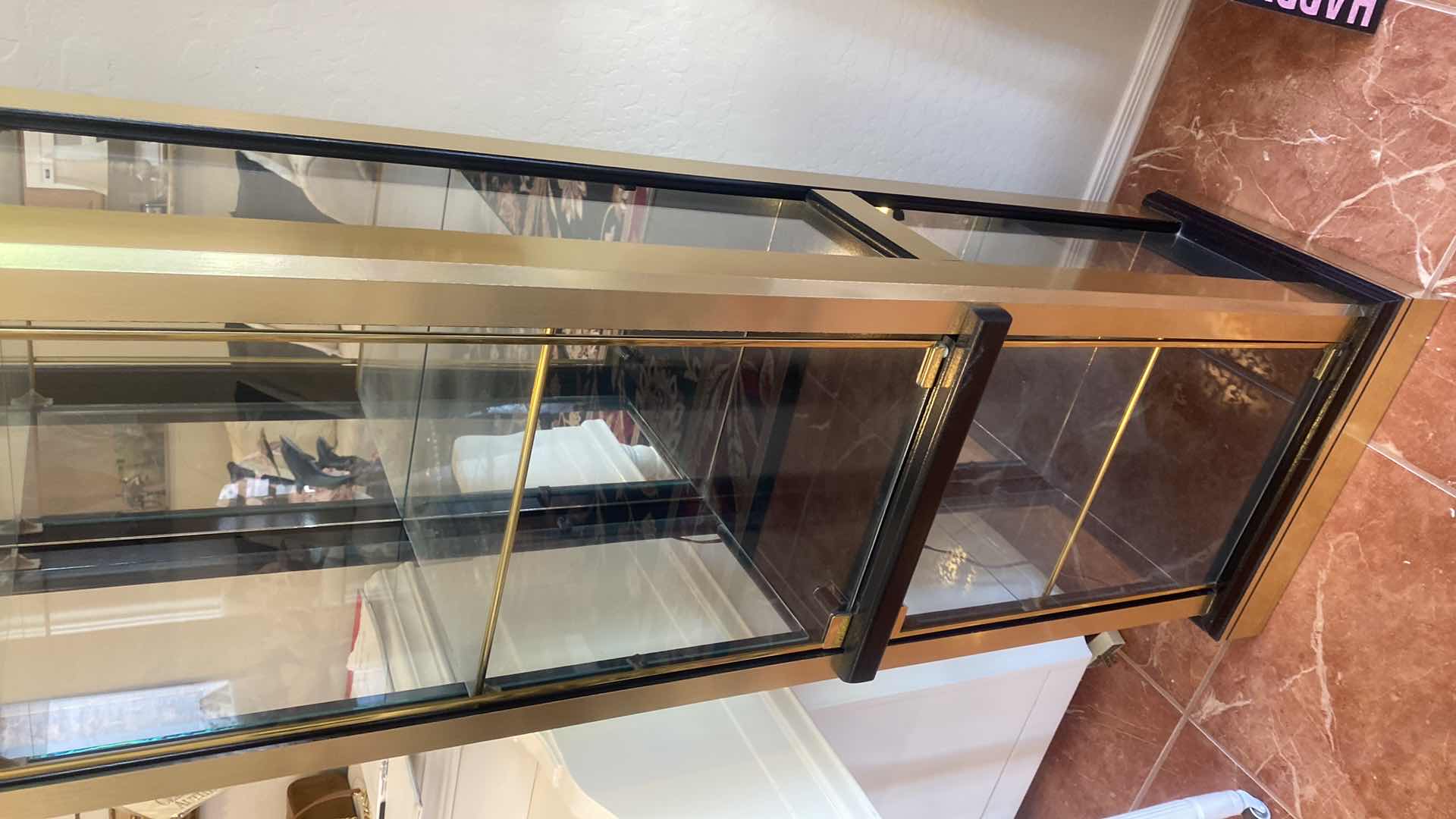 Photo 1 of GOLD & BLACK LIGHTED 2 DOOR DISPLAY CABINET W 3 ADJUSTABLE GLASS SHELVES 18 1/2” x 14” H 72” (two available each sold separately)