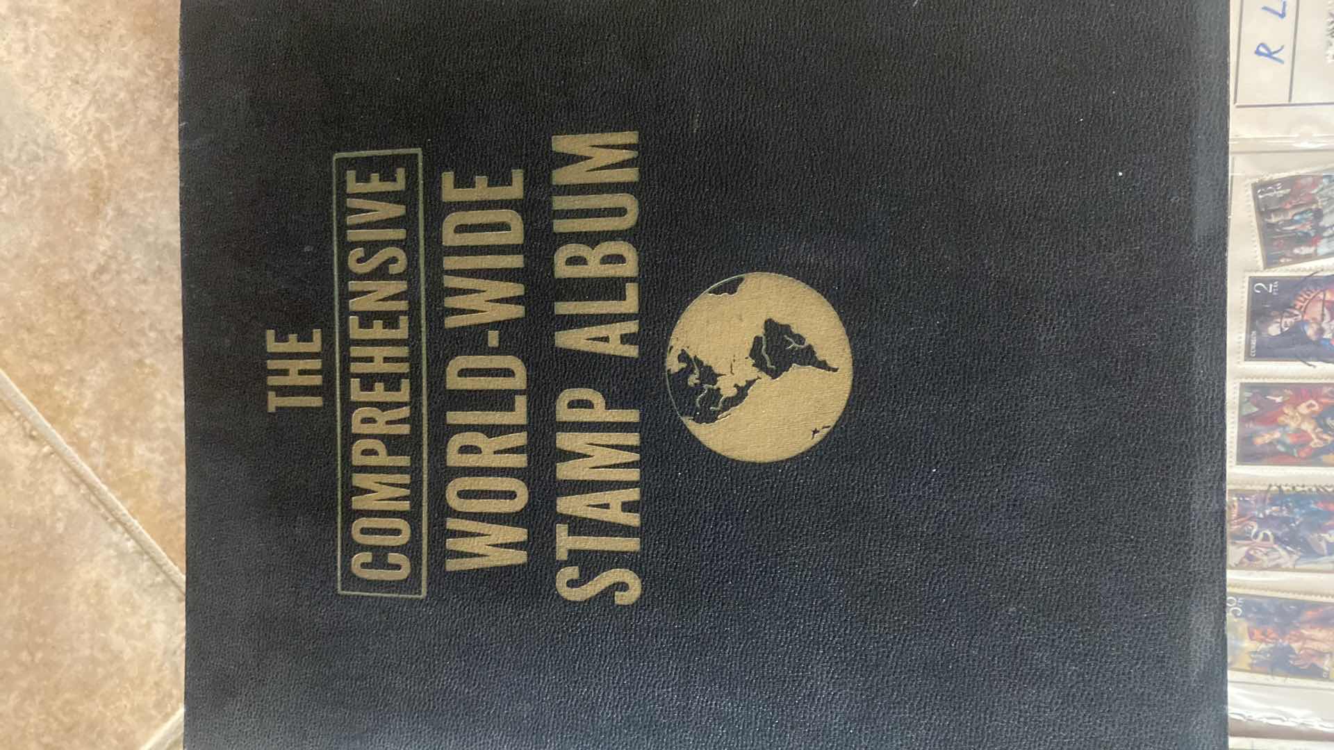 Photo 1 of THE COMPREHENSIVE WORLDWIDE STAMP ALBUM WITH ASSORTMENT OF STAMPS