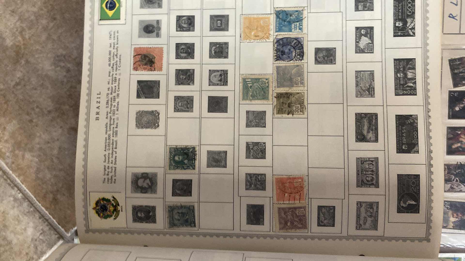 Photo 1 of THE COMPREHENSIVE WORLDWIDE STAMP ALBUM WITH ASSORTMENT OF STAMPS