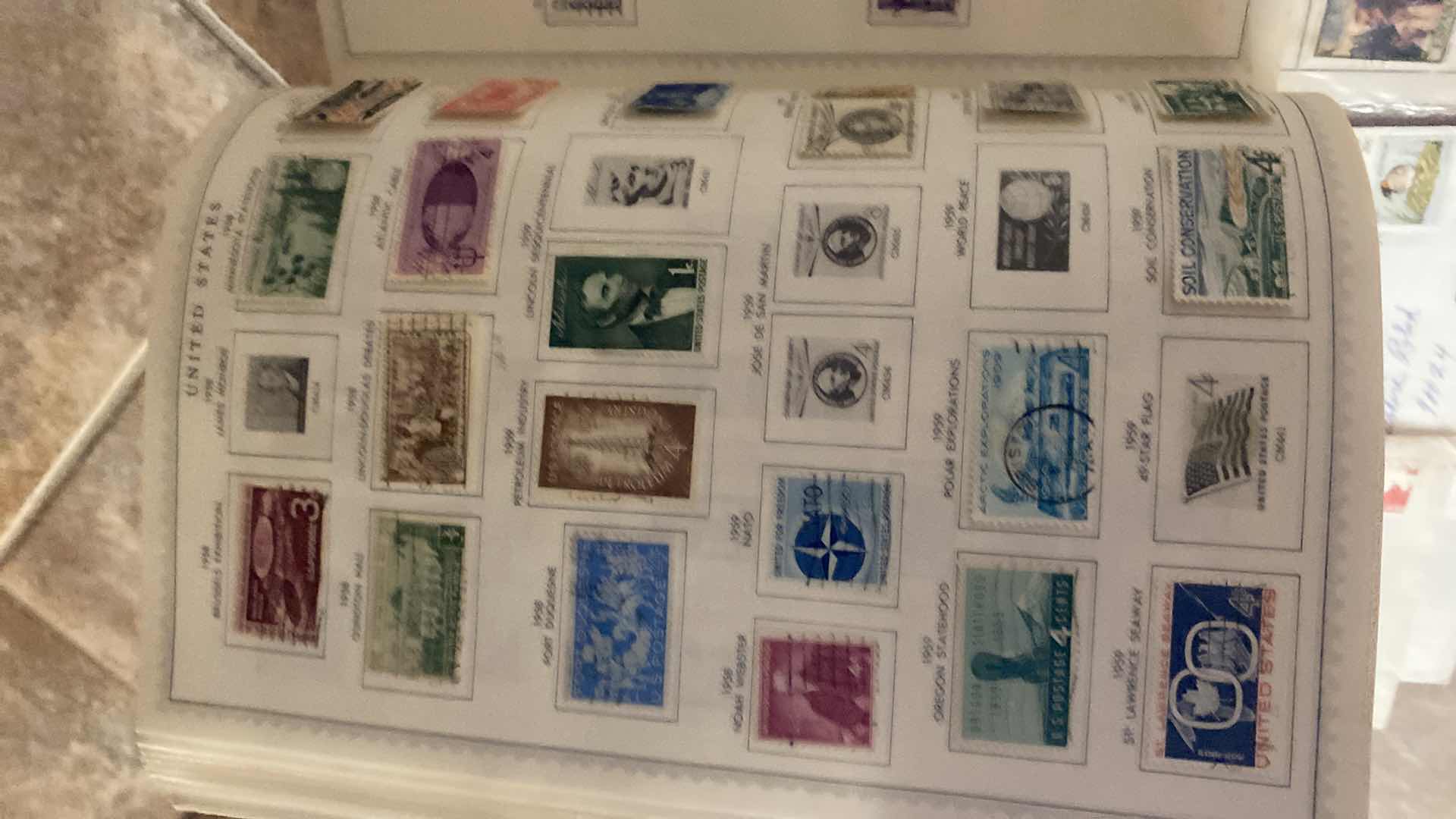 Photo 1 of THE COMPREHENSIVE WORLDWIDE STAMP ALBUM WITH ASSORTMENT OF STAMPS
