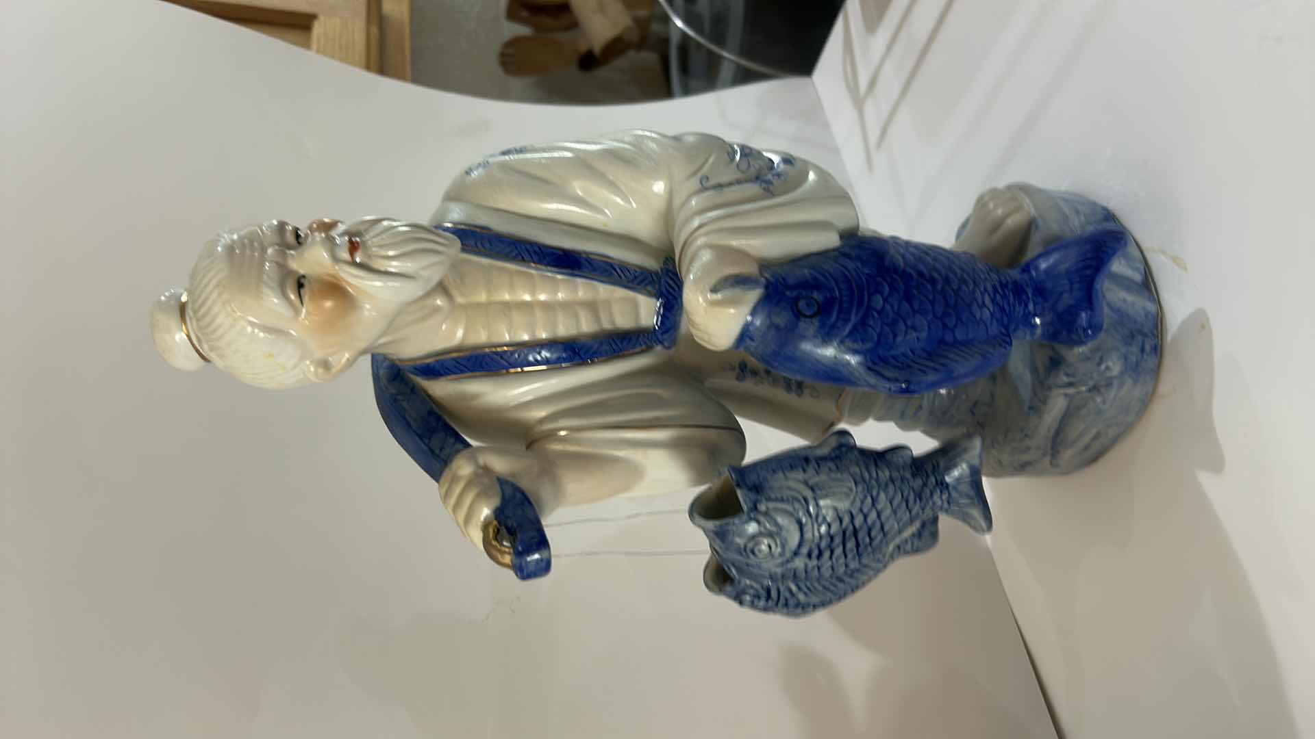 Photo 1 of VINTAGE BLUE & WHITE ASIAN PORCELAIN FISHERMAN FIGURINE DETAILED HAND-PAINTED FIGURE WITH FISH & HANGING VESSEL ESTIMATED RETAIL VALUE:$125 H16”