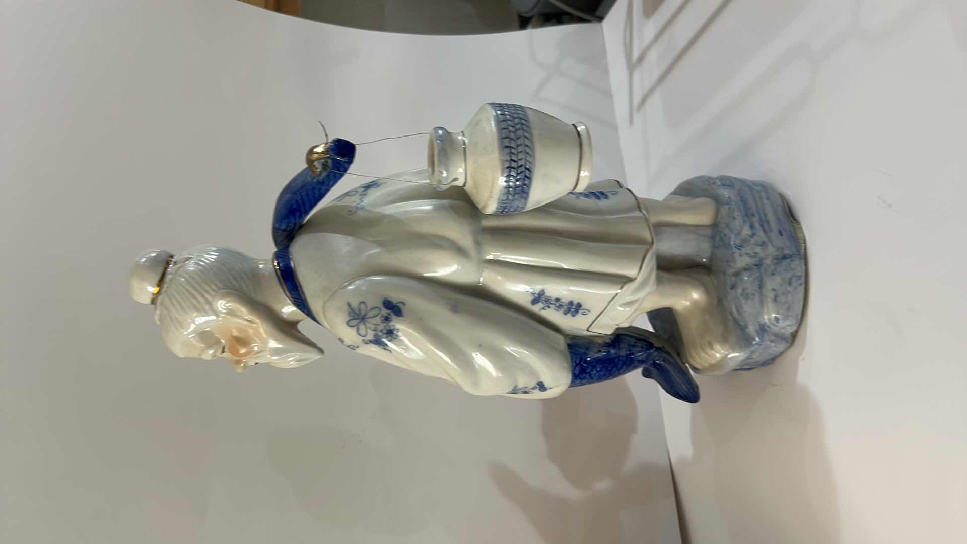 Photo 1 of VINTAGE BLUE & WHITE ASIAN PORCELAIN FISHERMAN FIGURINE DETAILED HAND-PAINTED FIGURE WITH FISH & HANGING VESSEL ESTIMATED RETAIL VALUE:$125 H16”