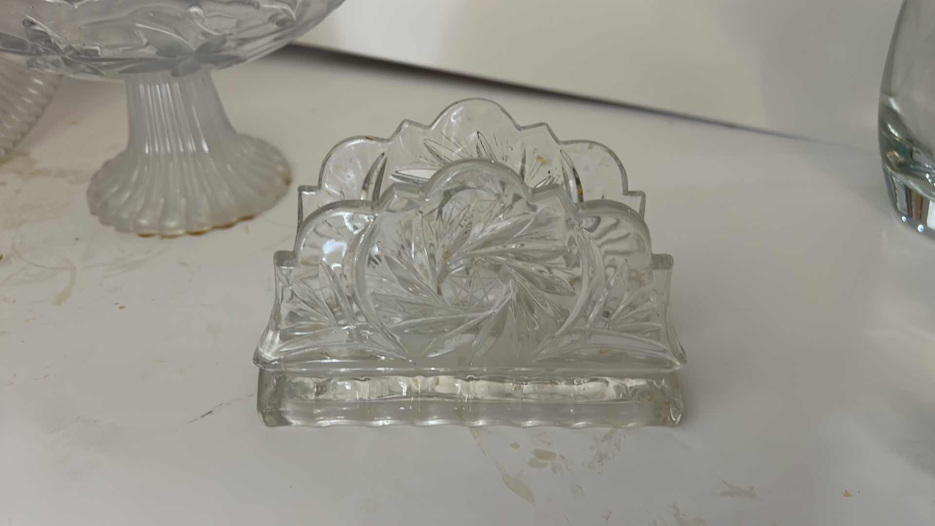 Photo 1 of ASSORTED VINTAGE CLEAR PRESSED GLASS SERVING PIECES INCLUDING DECORATIVE ROUND PLATTER, PEDESTAL COMPOTE AND FLORAL RELIEF DISH.
ESTIMATED RETAIL VALUE: $40–$60 FOR THE GROUP.