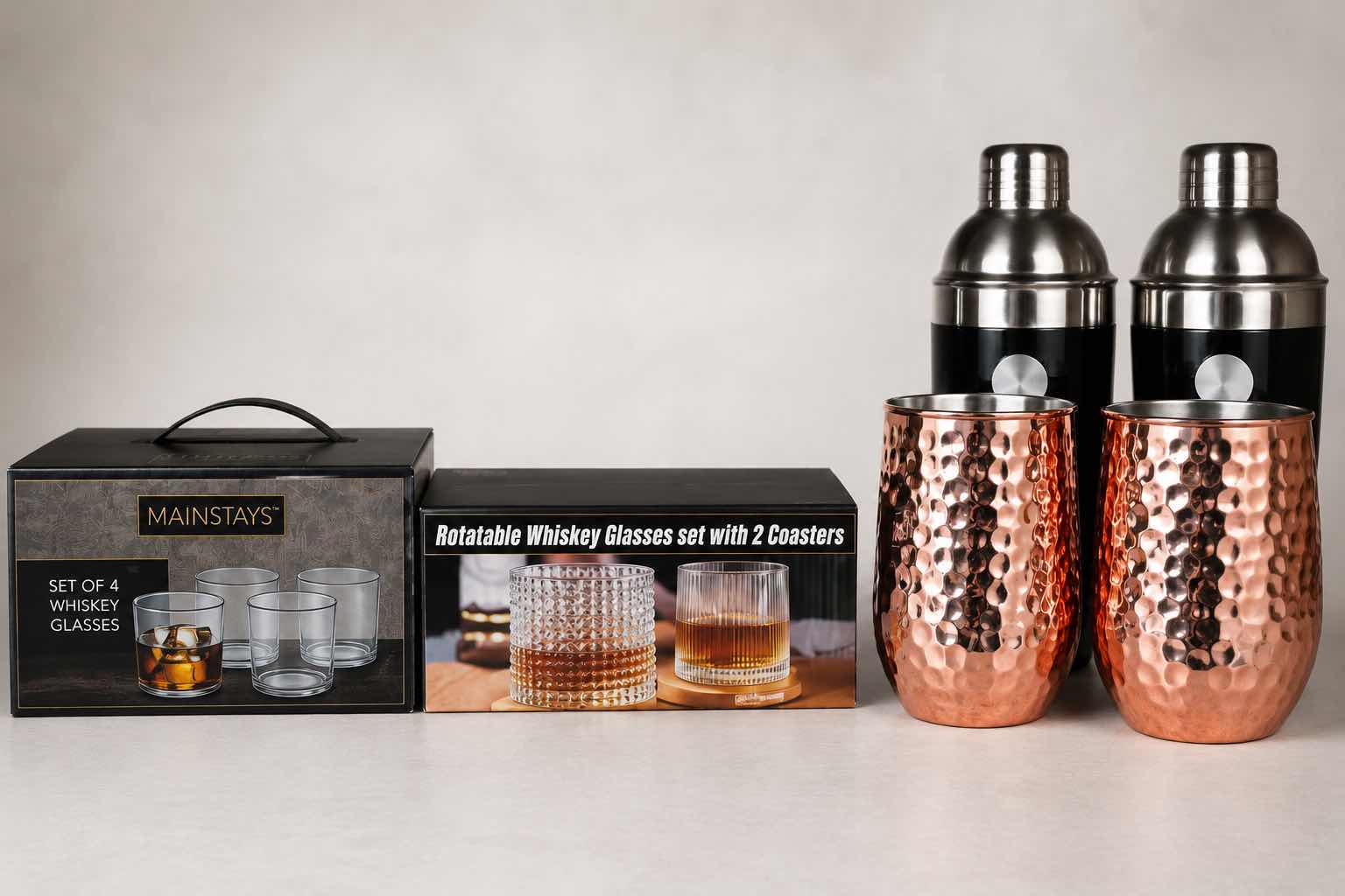 Photo 1 of ASSORTED HOME BARWARE INCLUDING MAINSTAYS WHISKEY GLASS SET, ROTATABLE WHISKEY GLASS SET WITH COASTERS, TWO COCKTAIL SHAKERS & TWO HAMMERED COPPER-TONE TUMBLERS.