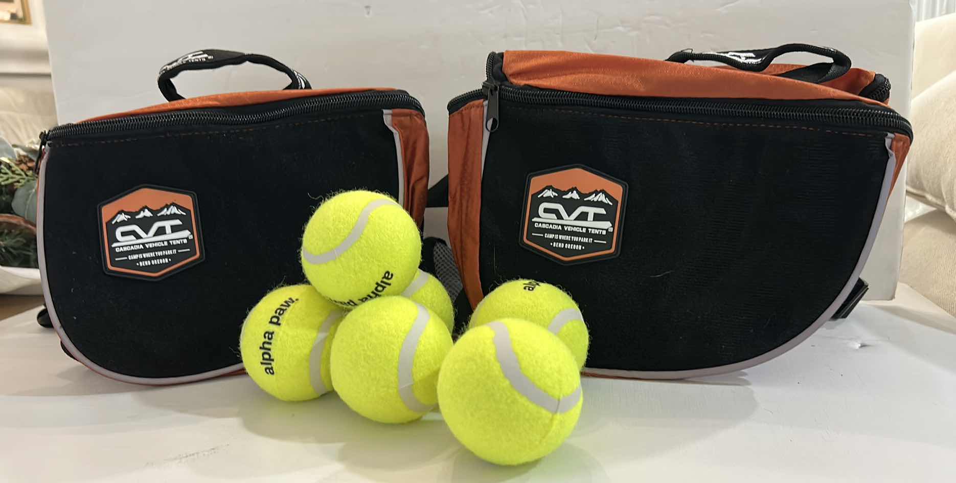 Photo 1 of NEW DOG ASSORTMENT- 2 SMALL CVT BACKPACKS/SADDLE BAGS AND 6 ALPHA PAWS TENNIS BALLS  $60
