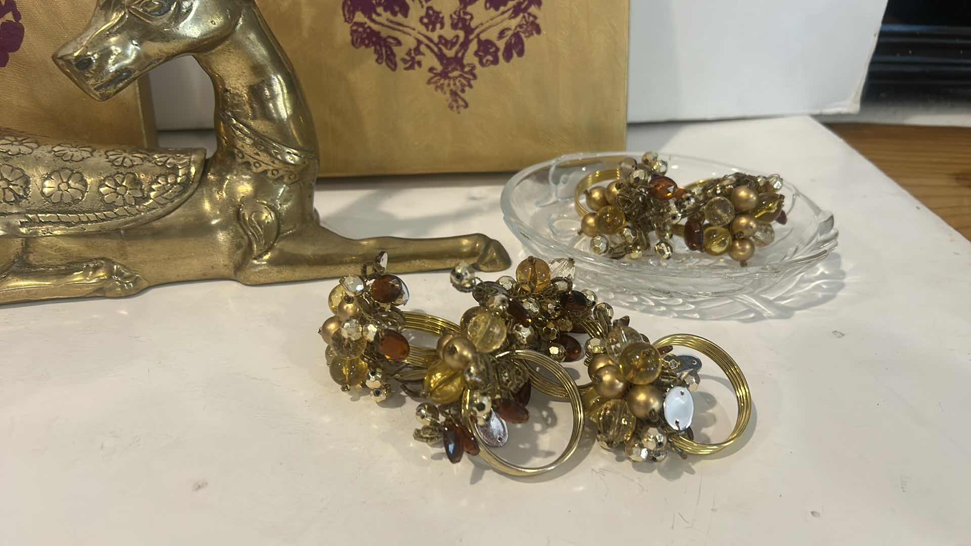 Photo 1 of CHRISTMAS DECOR /  LIDDED SANTA JAR, NAPKIN RINGS, BRASS REINDEER, ARTWORK & GLASS TRINKET DISH