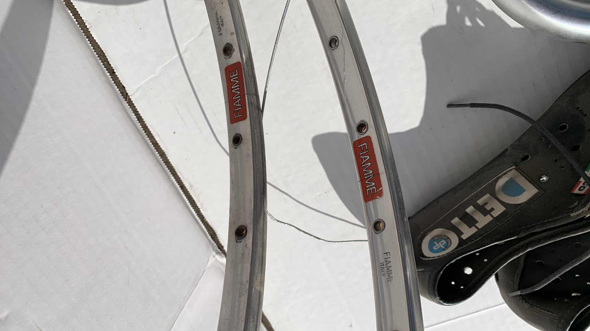 Photo 1 of ASSORTED BICYCLE PARTS AND ACCESSORIES, TO INCLUDE GEARS, BIKES SHOES SIZED 10, HANDLE BARS, RIM AND TIRE TUBES.